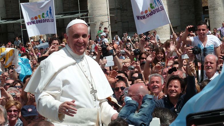 Papst Franziskus, umringt von einer Menschenmenge.