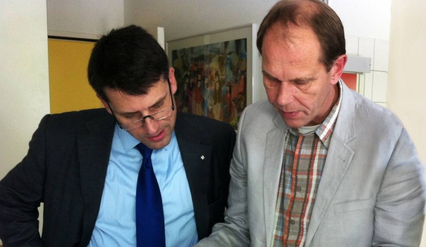 Gottfried Locher (links) mit Bildern von Asylsuchenden, die sich an den Fingerkuppen so stark verwunden, dass Fingerabdrücke nicht mehr möglich sind.