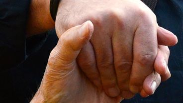 Eine Hand hält die andere.