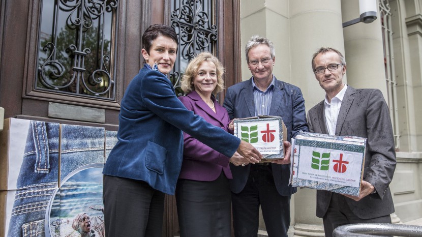Jacqueline Klaiss Brons, SBB-Leiterin Beschaffung, und Kathrin Amacker, SBB-Leiterin Kommunikation, erhalten die Unterschriften von Miges Baumann, Brot für alle, und Patrick Renz, Fastenopfer.