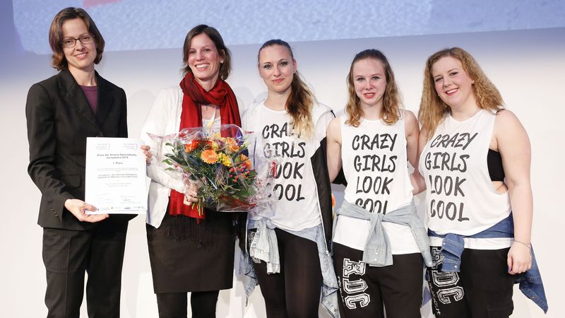 Preisübergabe an drei junge Frauen von