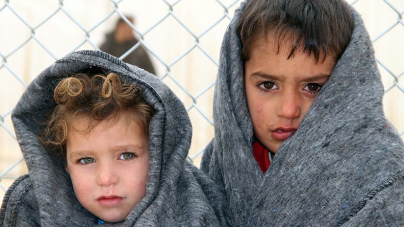 Zwei Kinder in Syrien in Decken gehüllt, die sie von einem Nothilfeprogramm erhalten haben.